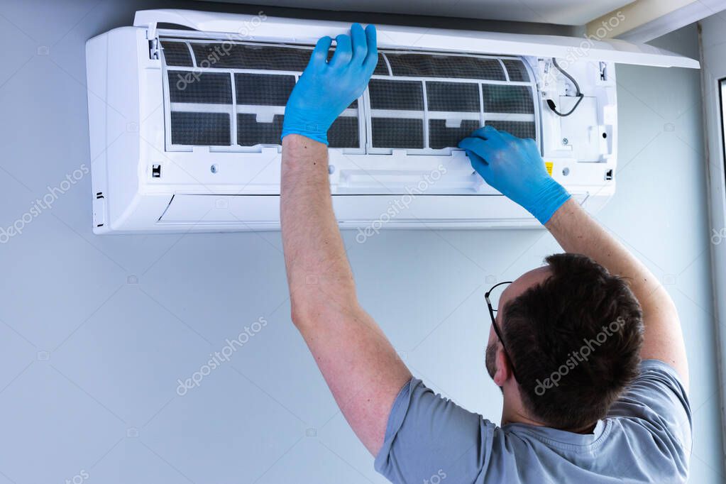Tecnico durante la manutenzione di un climatizzatore a parete